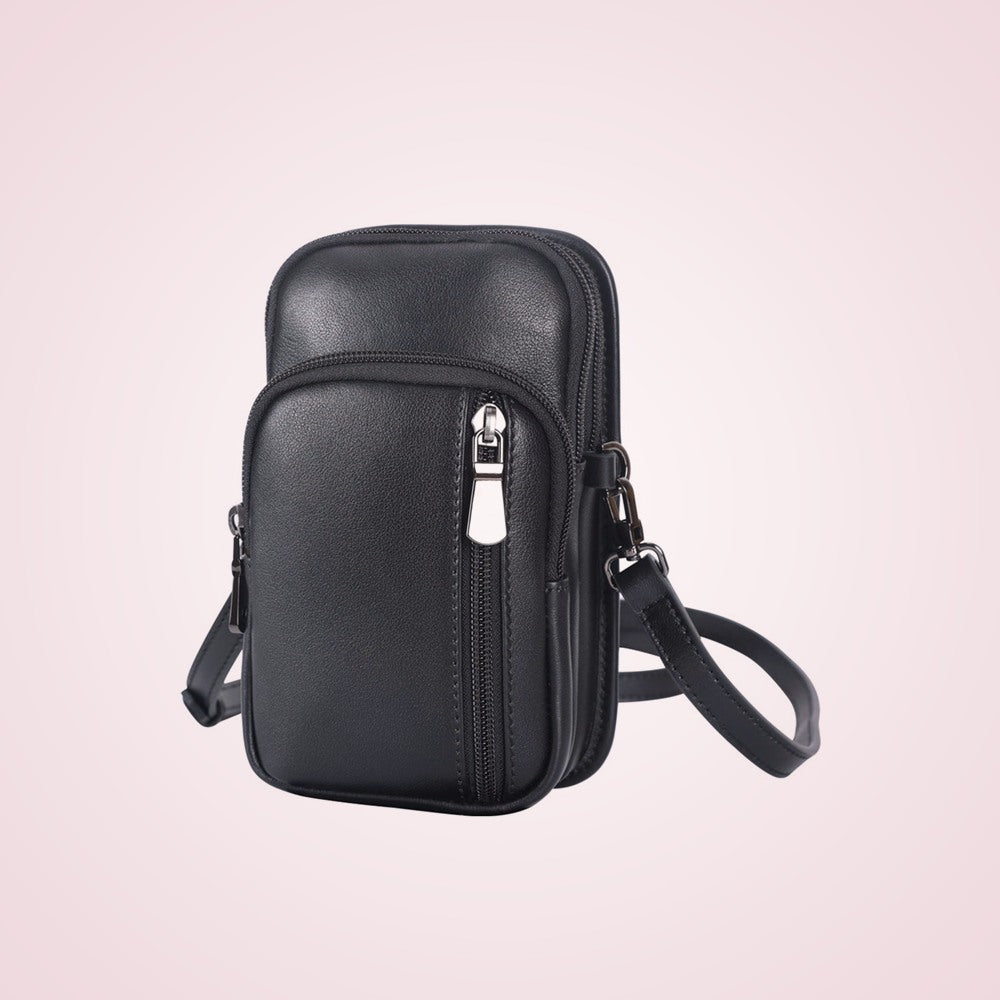 Black leather mini messenger bag on a soft rose background