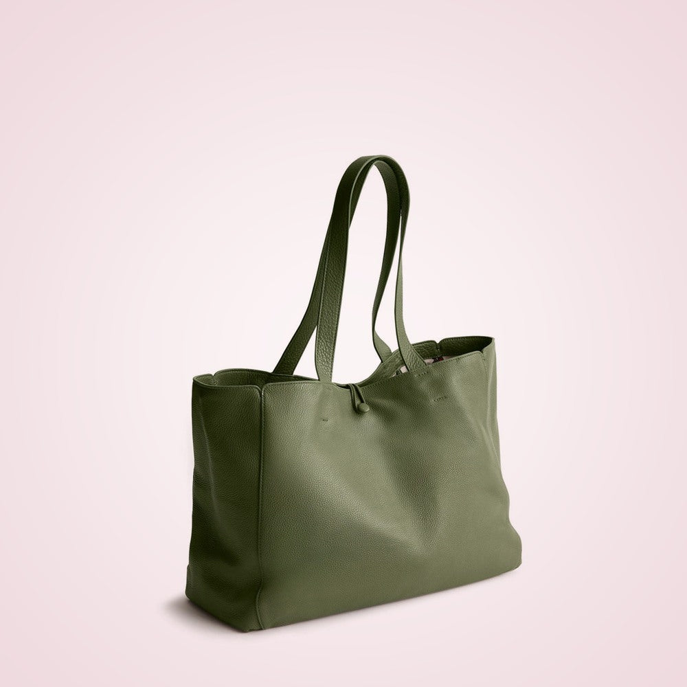 Olive green pebbled leather tote bag on a soft rose background